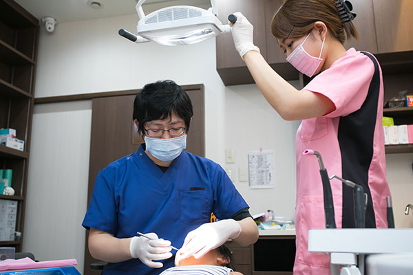 治療中の歯科医師と歯科衛生士
